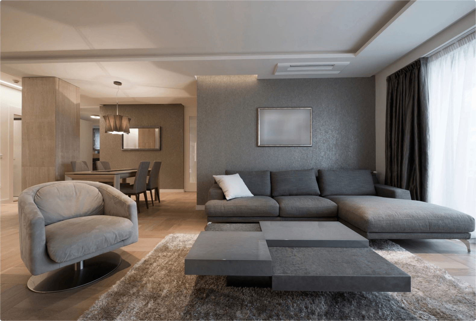 A living room with gray furniture and a table.