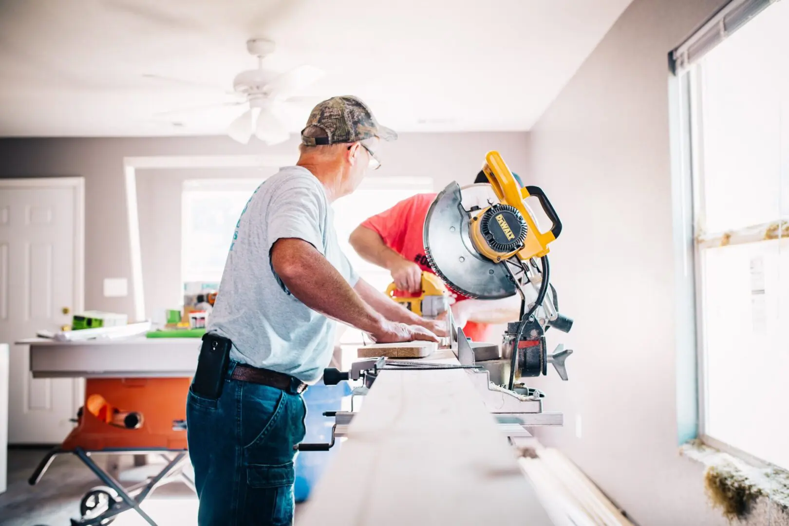 Two men working on a kitchen counter top.