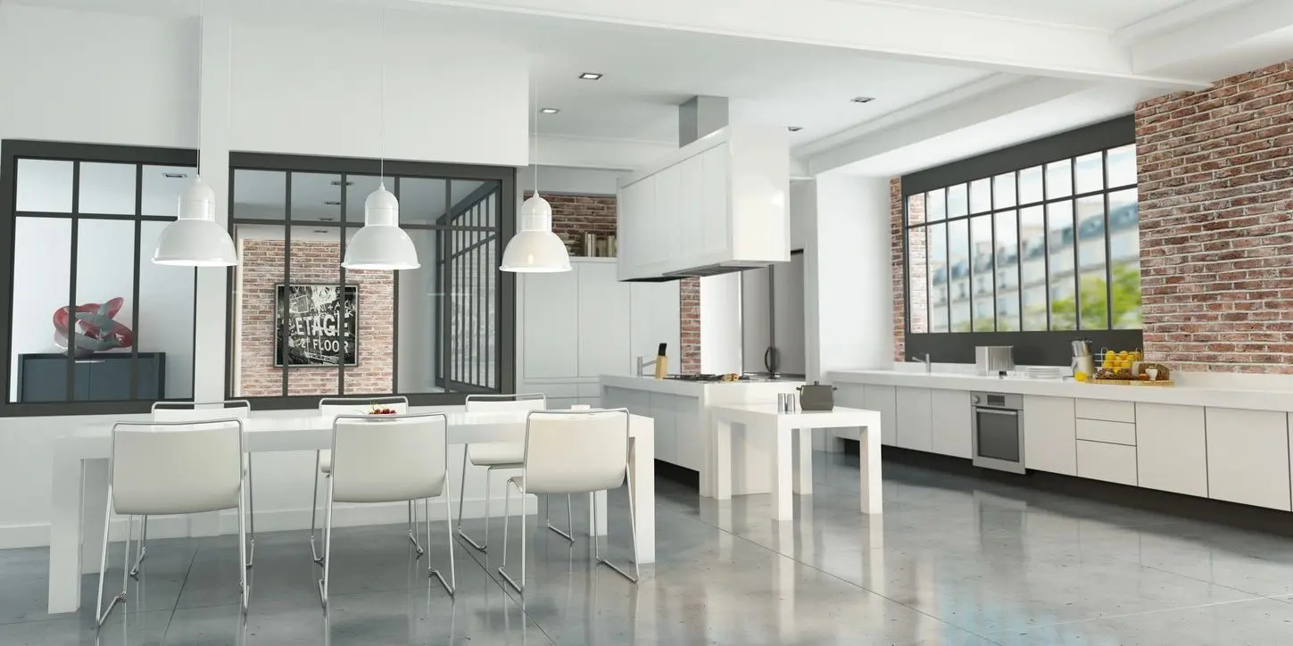 A white kitchen with an island and dining table.