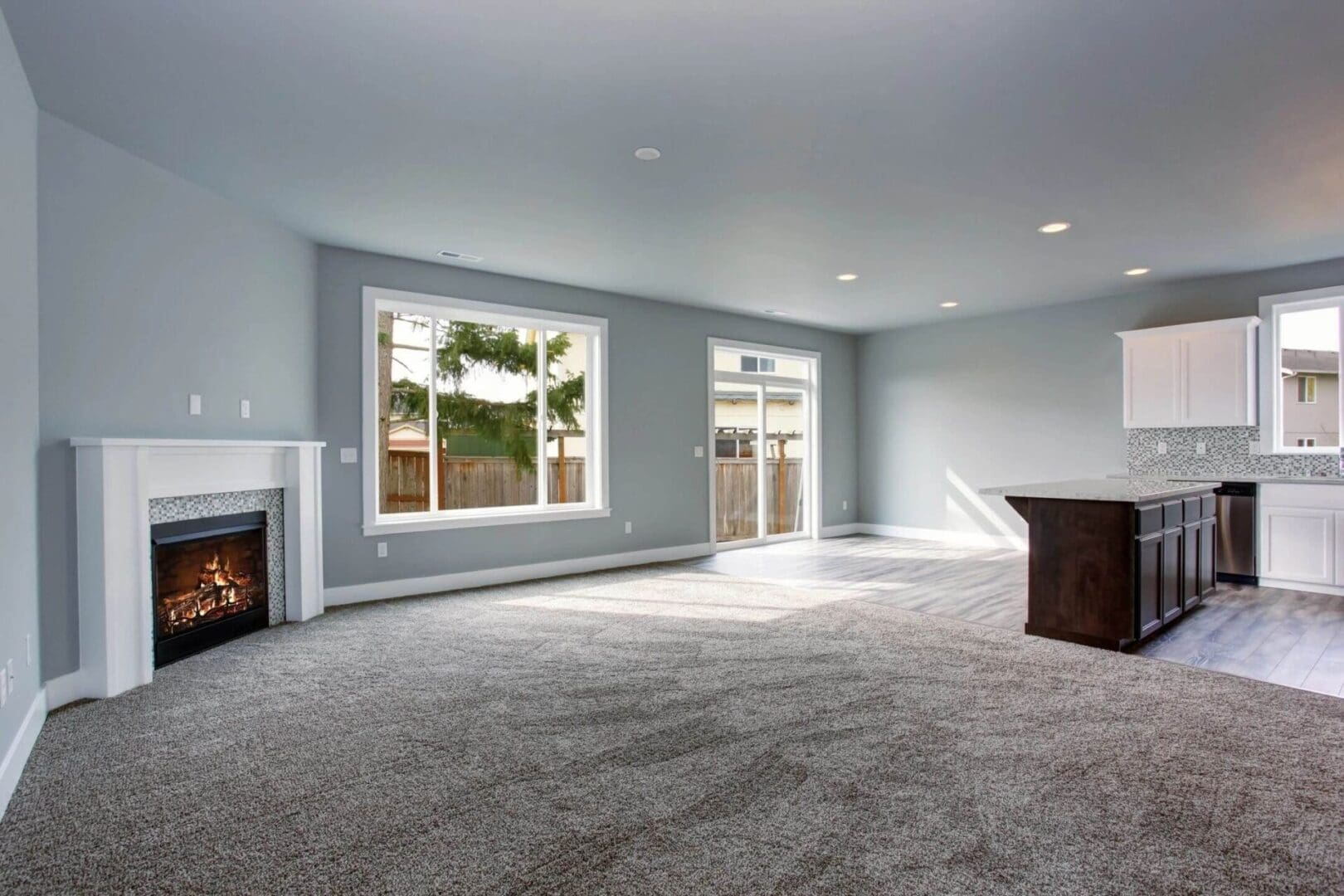 A living room with a fireplace and large windows.