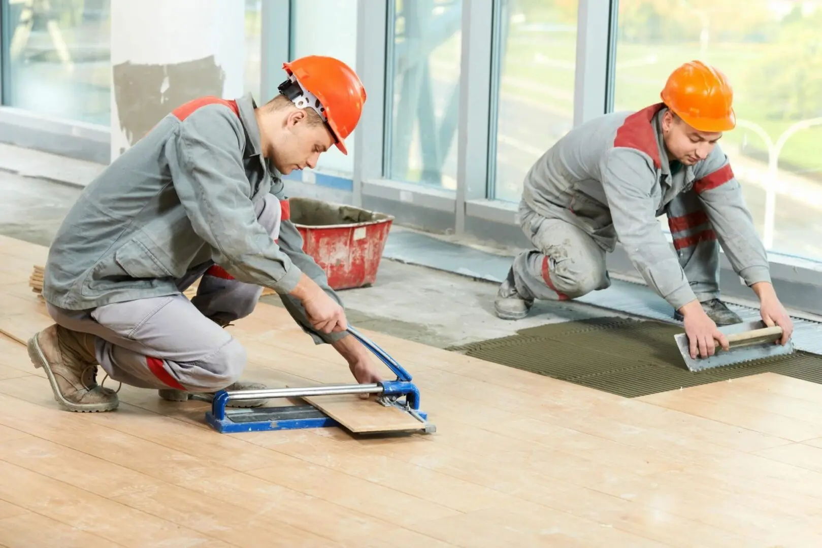 Two men in grey work vests and hard hats.